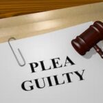 Plea guilty document with judge gavel on legal paperwork representing plea bargaining in criminal court