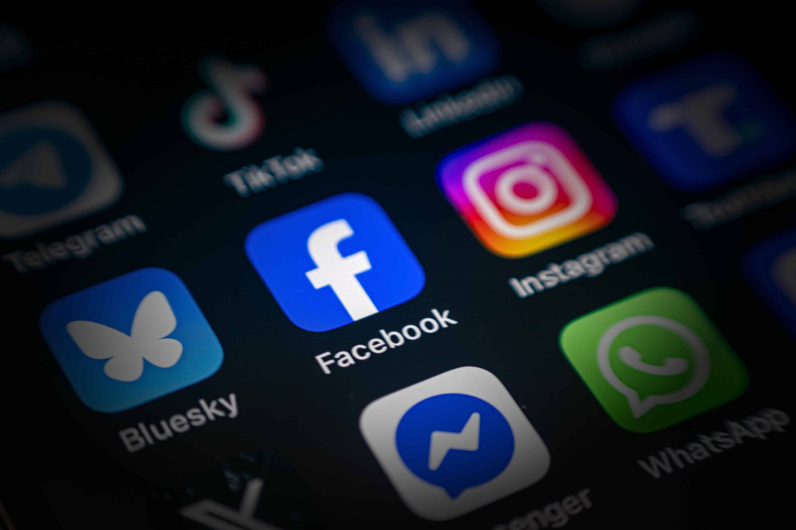 Smartphone screen displaying social media app icons including Facebook, Instagram, TikTok, WhatsApp, and Messenger.