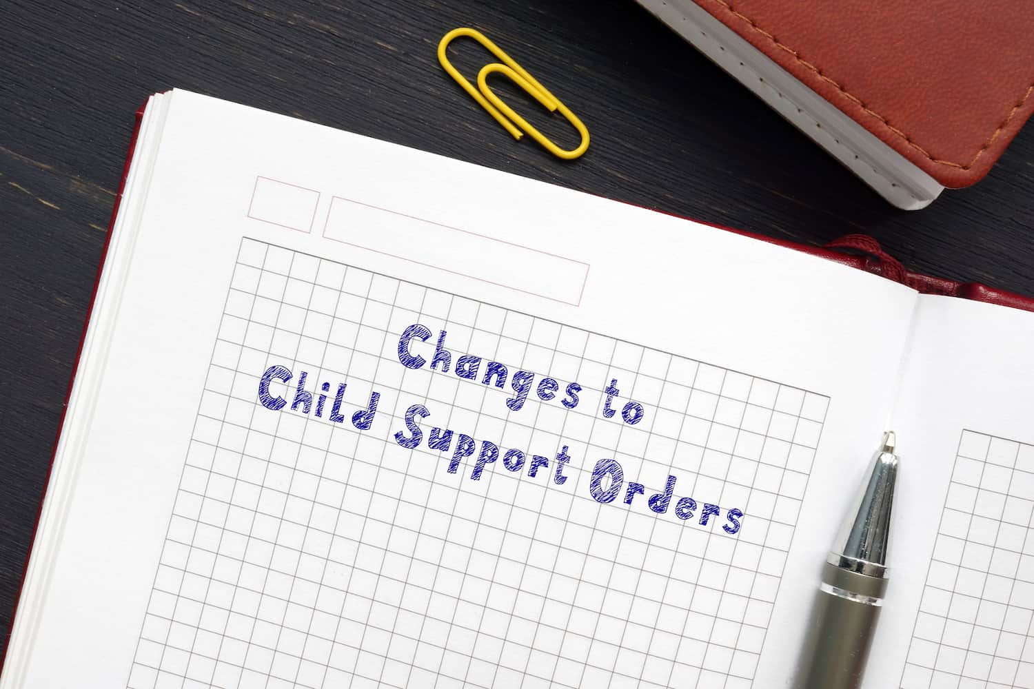 Changes to Child Support Orders Legal Modification Concept Changes to child support orders written in notebook with pen on desk, legal modification concept